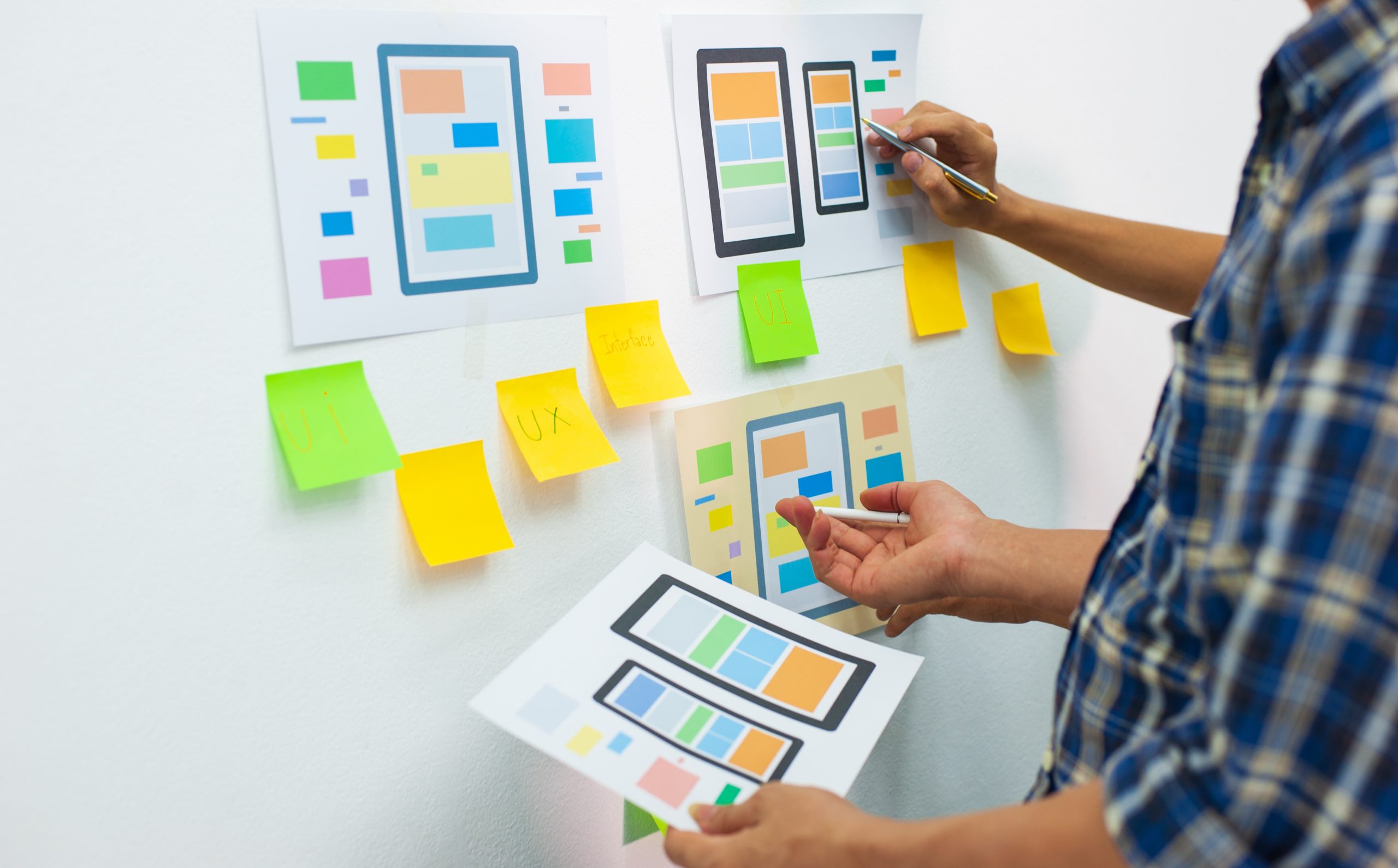  web designers work together to plan user interface layouts 